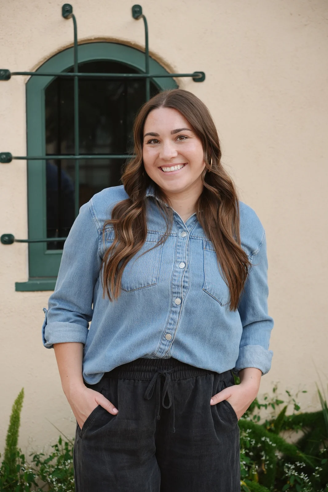 Faith Vargas smiling beside a green arched doorway